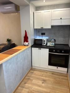 a kitchen with white cabinets and a black appliance at Urban Apart in Stara Zagora