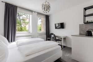 a hotel room with two beds and a desk at Davin City Aparments - Self-Check-In in Hamburg