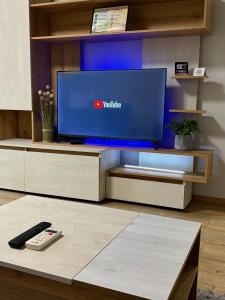 a remote control sitting on a table in front of a tv at Urban Apart in Stara Zagora