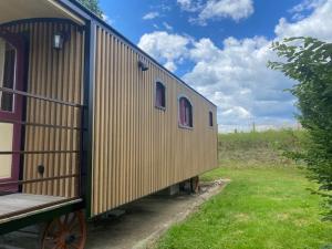 a house is sitting on the side of a field at La Roulotte au Paradis in Arc-et-Senans
