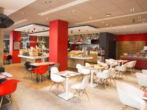 a restaurant with tables and chairs and a counter at Ibis Sfax in Sfax