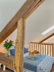a bedroom with a wooden bed with a vase of flowers at Le secret du Morvan in Saulieu