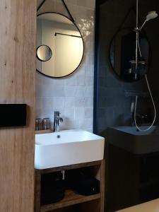a bathroom with a white sink and a mirror at B&B En face du Marronnier in Cornimont