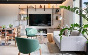 a living room with a couch and chairs and a table at Campanile NATURE - Bordeaux Sud Pessac in Pessac