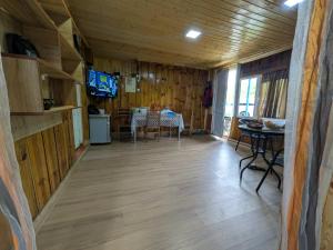 a dining room with a table and a television in a cabin at Iamze's Guest House in Mestia