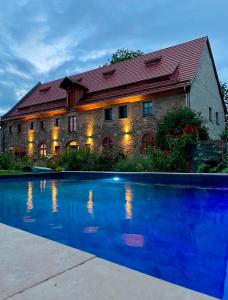 a house with a swimming pool in front of it at Historischer Kornspeicher mit Pool am Selketal, Natururlaub im Harz in Ermsleben