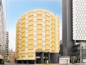 a yellow building in the middle of a city at Chisun Inn Nagoya in Nagoya