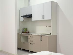 a kitchen with white cabinets and a sink at CMC Hotel Apartment in Samarkand