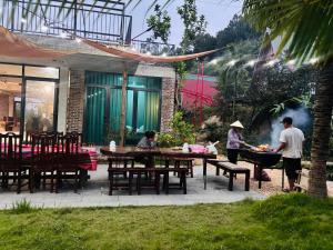 a group of people cooking food in a garden at BIRD HOUSE resort in Hữu Biêt