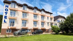 a building with two cars parked in front of it at Hotel Imperium in Moravske-Toplice +80 photos