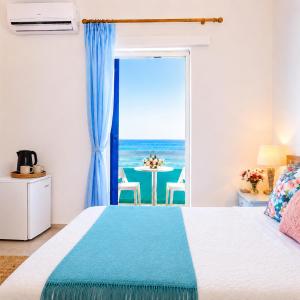 a bedroom with a bed and a view of the ocean at Klima Rooms in Palaiochora