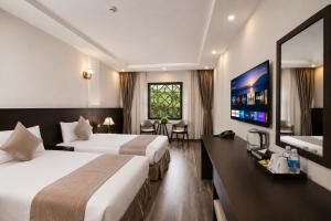 a hotel room with two beds and a flat screen tv at Lacasa Sapa Hotel in Sapa