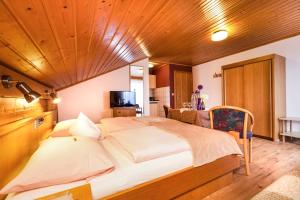 a bedroom with a large bed with a wooden ceiling at Genusshotel Hohenbogen GARNI in Neukirchen beim Heiligen Blut