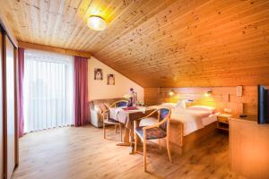 a bedroom with a bed and a table and chairs at Genusshotel Hohenbogen GARNI in Neukirchen beim Heiligen Blut