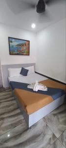 a bedroom with a bed with a painting on the wall at Hotel Bougainvillea in Cochin