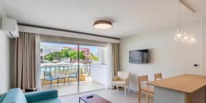 a living room with a blue couch and a table at Servatur Isora Suites in Puerto de Santiago +38 photos