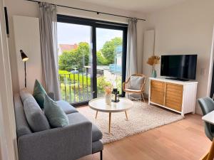 a living room with a couch and a tv and a table at Lilla Villa - Pá stranden - in Kellenhusen