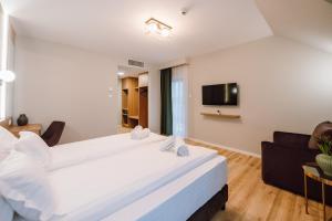 a hotel room with a large bed and a tv at Vila Bernady Sovata in Sovata