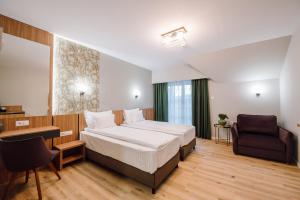 a hotel room with a bed and a chair at Vila Bernady Sovata in Sovata +43 photos