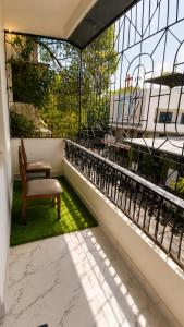 a balcony with a chair and a window at Thaanya Guest Rooms in Chinchwad