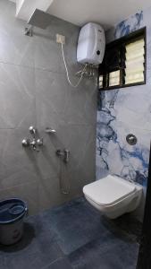 a bathroom with a toilet and a shower stall at Thaanya Guest Rooms in Chinchwad