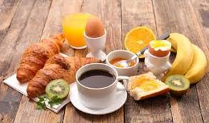 a breakfast of eggs and croissants and coffee on a wooden table at Montebello in Bellinzona