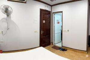 a room with a bed and a fan and a door at Anh Duong Hotel in Noi Bai