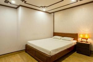 a bedroom with a bed with two lamps on it at Anh Duong Hotel in Noi Bai