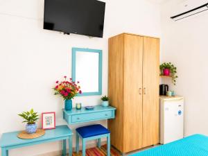 a room with a desk and a cabinet with a mirror at Klima Rooms in Palaiochora
