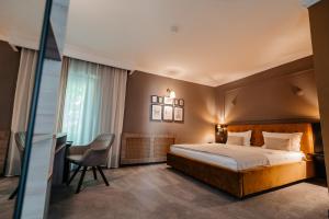 a hotel room with a bed and a desk at Hotel Cocó in Timişoara