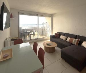 a living room with a couch and a table at Le Grand Large - T2 vue océan in Mimizan-Plage