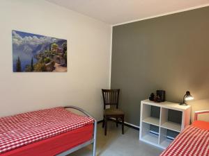 a bedroom with two beds and a table and a chair at Revier schlicht und bahnsinnig in Mitlödi