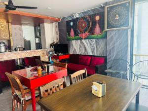 a dining room with a table and a red couch at The Nice Patong Hotel in Patong Beach