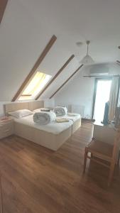 a white bedroom with a bed and a chair at Casa Salcia Oituz in Oituz