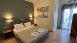 a bedroom with a bed with two towels on it at Anthoussa Rooms in Parga