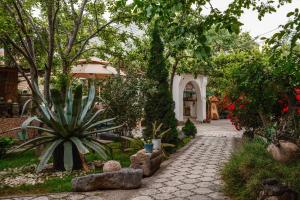 a walkway in a garden with trees and plants at Art Hotel Al Hayat in Kaji-Say