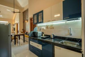 a kitchen with a sink and a microwave at Aloha Kai Modern Chic 2BHK Benaulim in Benaulim