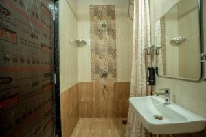 a bathroom with a sink and a shower with a mirror at Aloha Kai Modern Chic 2BHK Benaulim in Benaulim