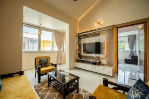 a living room with a fireplace and a tv at Aloha Kai Modern Chic 2BHK Benaulim in Benaulim