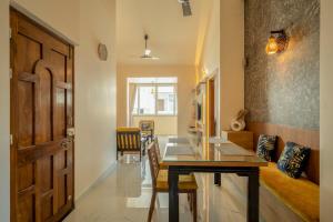a dining room with a table and a wooden door at Aloha Kai Modern Chic 2BHK Benaulim in Benaulim +35 photos