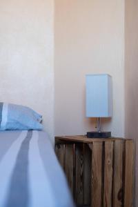 a bedroom with a bed and a lamp on a wooden stand at NIDO SCANSANESE in Scansano +8 photos