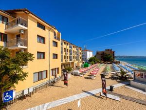 a beach with a bunch of umbrellas and chairs at Palma Beach Hotel in Kranevo