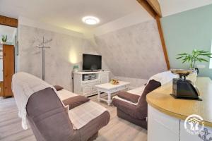 a living room with two couches and a tv at De l'ar mor bihan in Riantec