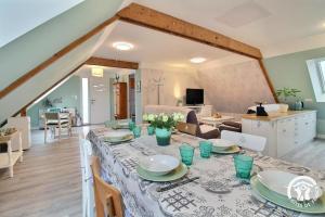 a dining room and living room with a table at De l'ar mor bihan in Riantec
