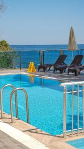 a swimming pool with chairs and the ocean in the background at Er Suite in Alanya