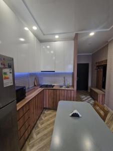 a kitchen with a table and a refrigerator at Sky Nest Batumi in Batumi