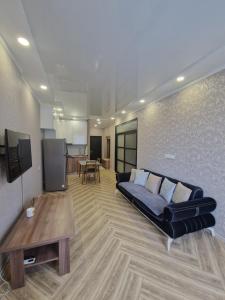 a living room with a couch and a table at Sky Nest Batumi in Batumi