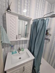 a bathroom with a sink and a shower with a mirror at Sky Nest Batumi in Batumi +11 photos