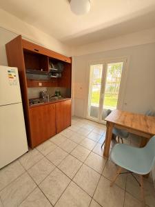 a kitchen with a table and a refrigerator at Amphitrite's Paradise Apartments in Olympic Beach +55 photos