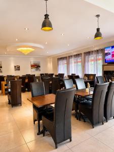 a conference room with wooden tables and black chairs at Hôtel Restaurant le Mistral in Peipin